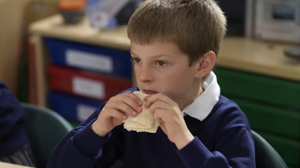 Schoolchild eating lunch in classroom