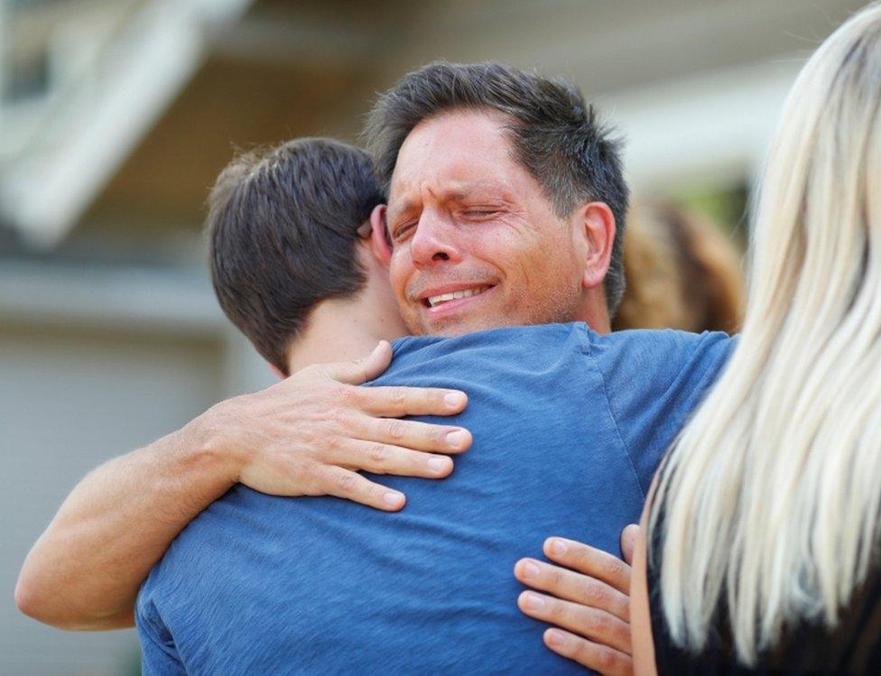 Don Damond hugs a neighbour after reading a statement about his fiancé