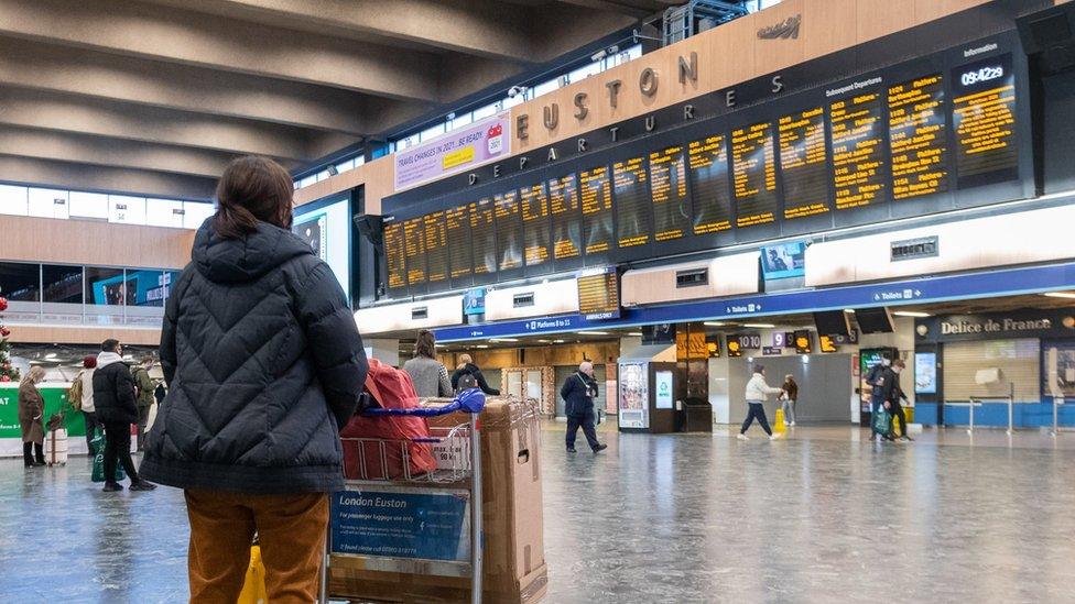 Passengers at Euston Station wait to find out if their trains are running on time as they prepare to leave the capital on December 19, 2020 in London