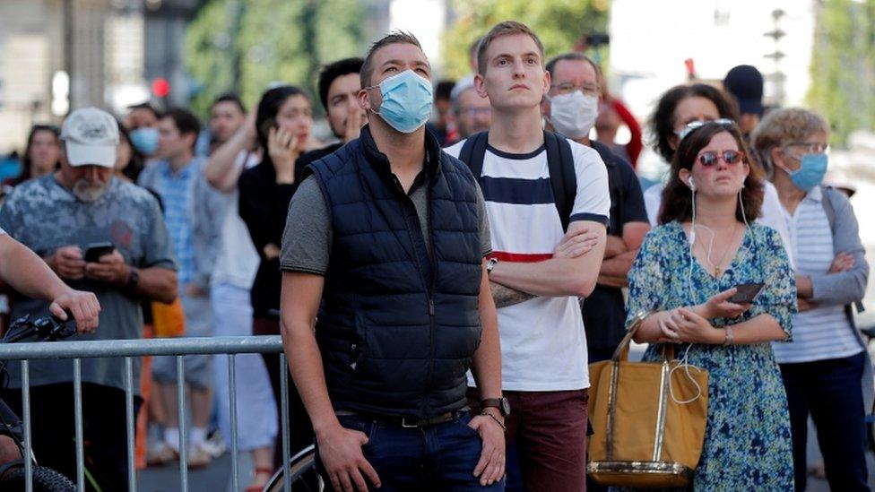 Bystanders watch the scene of the fire