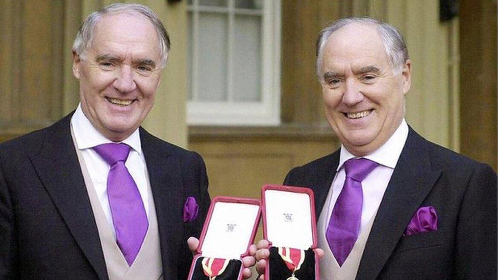 Sir David Barclay (L) and his twin brother Sir Frederick posing after receiving their knighthoods from the Queen at Buckingham Palace