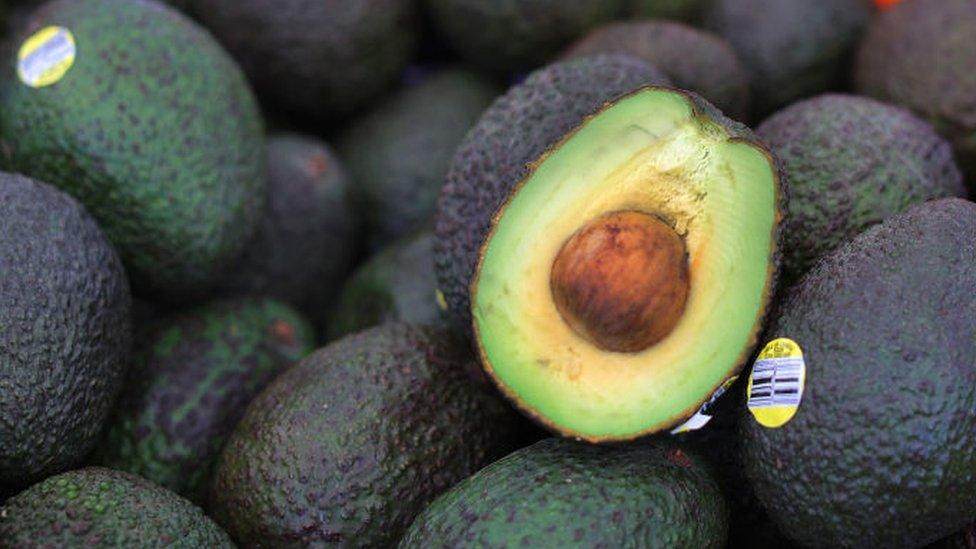 Avocados laid out on a market stall