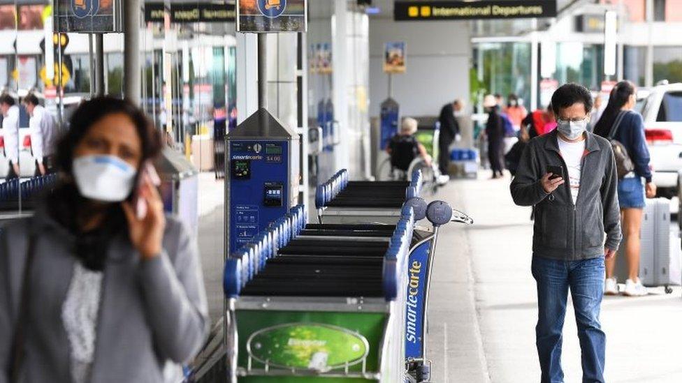 People wear masks at Melbourne's airport, Australia. Photo: 13 March 2020