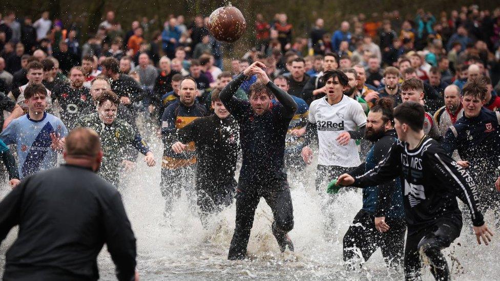 There are rivers, bridges and bogs to navigate between the two goals, which are three miles apart - players run through the river to fight for the ball