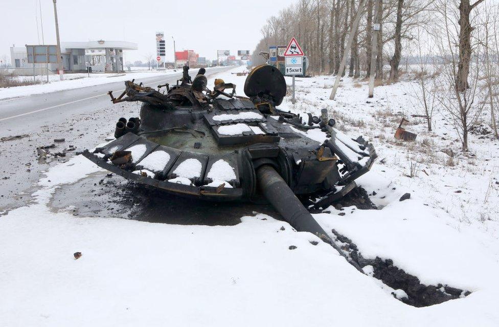 A blown-off tank turret lies on the ground on the outskirt of Kharkiv