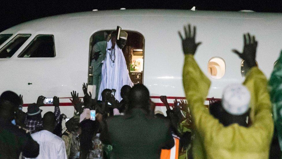 Former president Yaya Jammeh, the Gambia's leader for 22 years, waves from the plane as he leaves the country on 21 January 2017 in Banjul