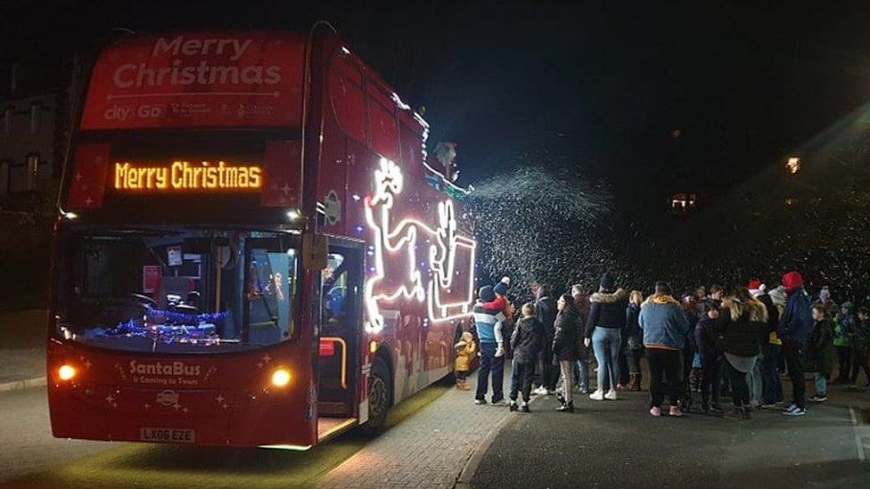 Christmas bus with crowd of people outside