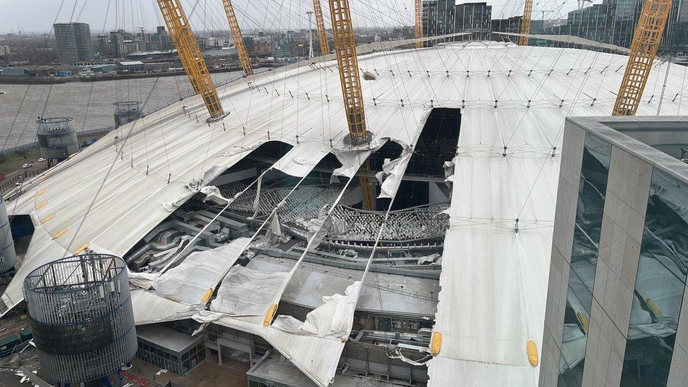 A large section of the roof of the Millennium Dome is seen torn away