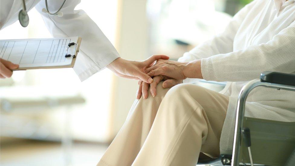 Doctor examining patient in wheelchair