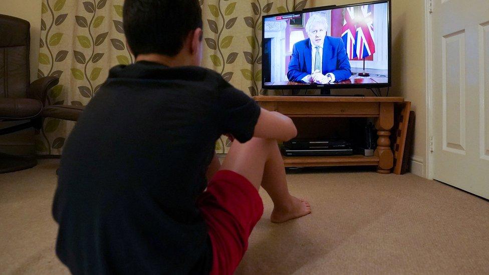 Boy watches PM address on TV