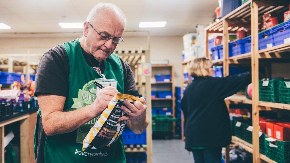 Mae'r gwirfoddolwyr yn labelu'r bwyd gyda dyddiadau defnyddio