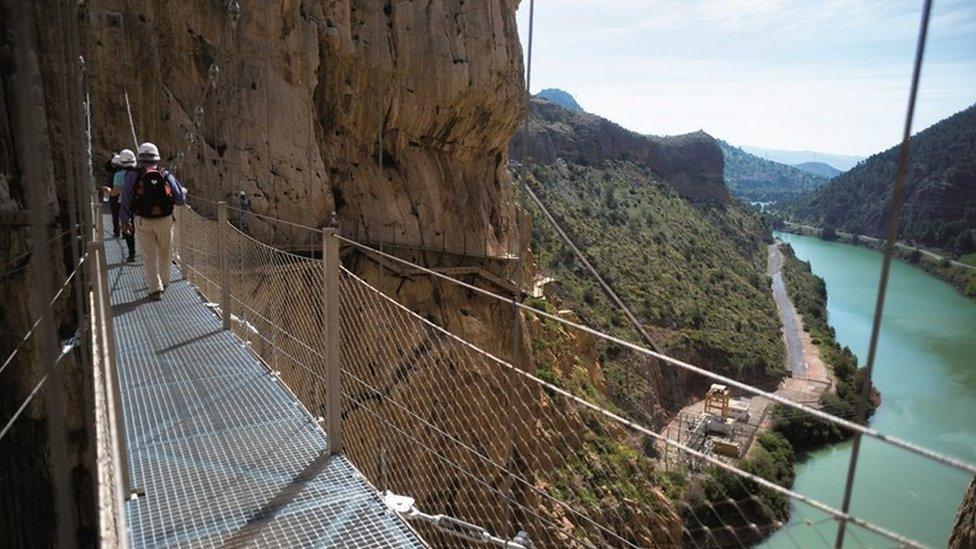 Saga tourists walking across a bridge