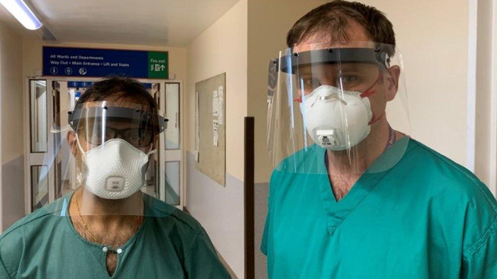 Two doctors wearing PPE face shields