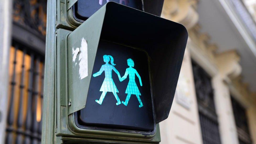 Green-traffic-light-shows-figures-holding-hands.