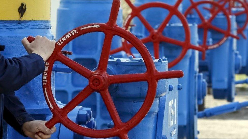 An employee turns a valve at a gas compressor station in the village of Boyarka, outside Kiev