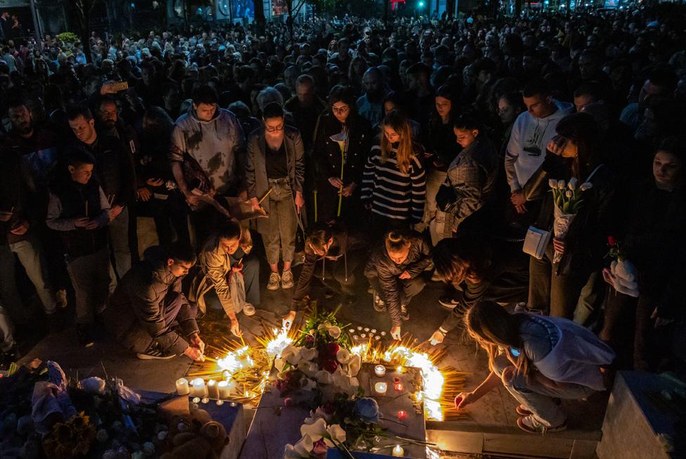 People leave flowers and light candles near the Vladislav Ribnikar school in Belgrade, Serbia