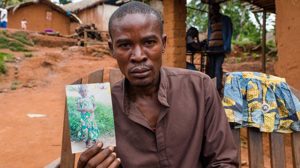 Abdula holds a picture of his daughter