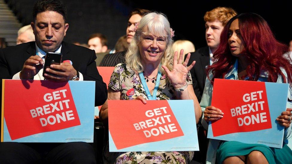 Delegates at Conservative Party Conference holding "Get Brexit Done" signs