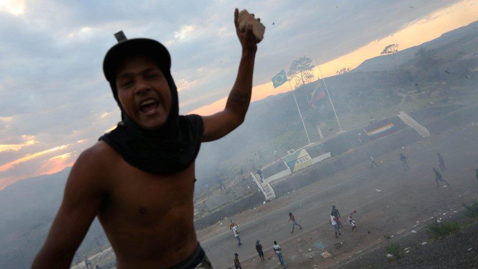 A protestor holds a projectile