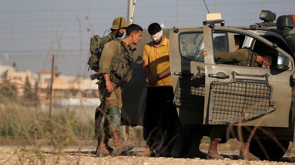 Israeli troops detain a man near the northern Israeli village of Muqeibla while searching for six Palestinian prisoners who escaped Gilboa jail (6 September 2021)