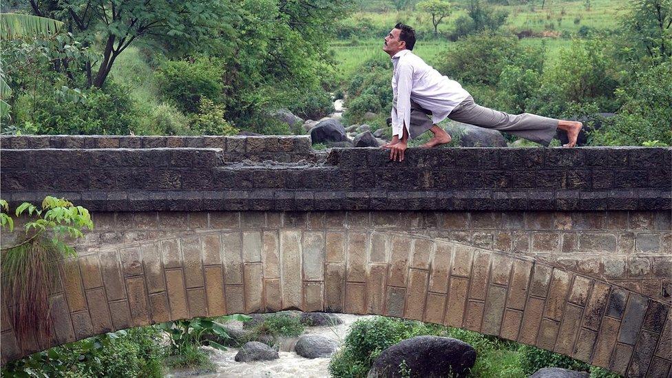 An Indian man performs yoga to mark the international Day of Yoga, in the rain at Baldhar Village, near Dharamsala, India 21 June 2017.