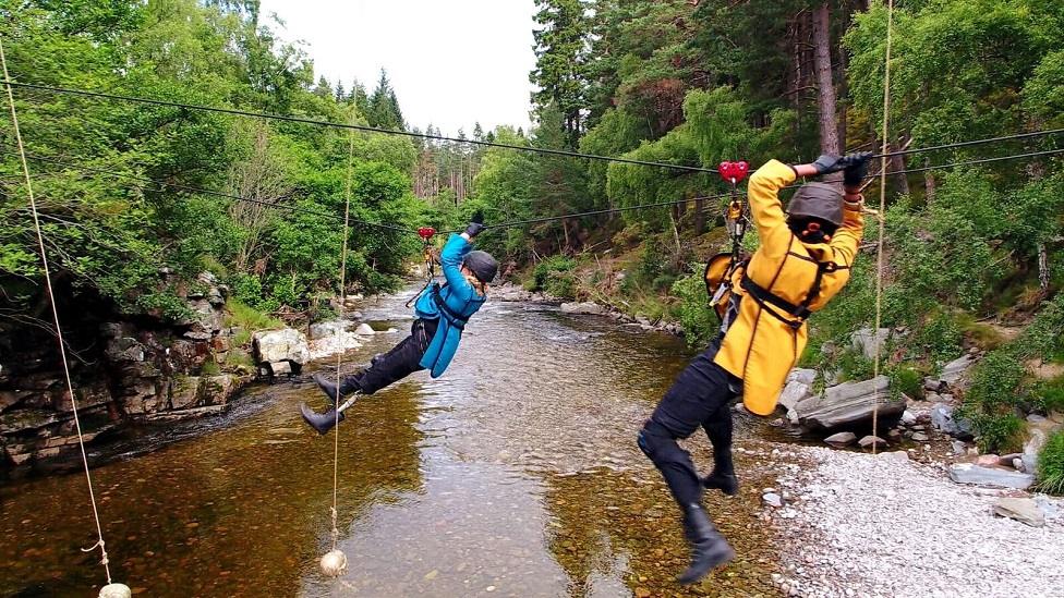 Hannah crosses a river using a wire