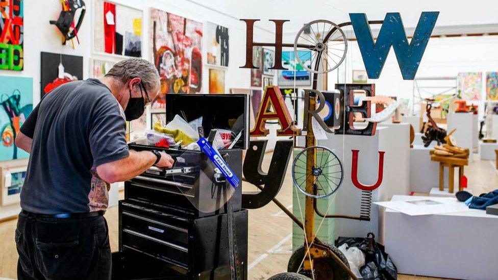 A technician displaying the pieces of art ready for the exhibition