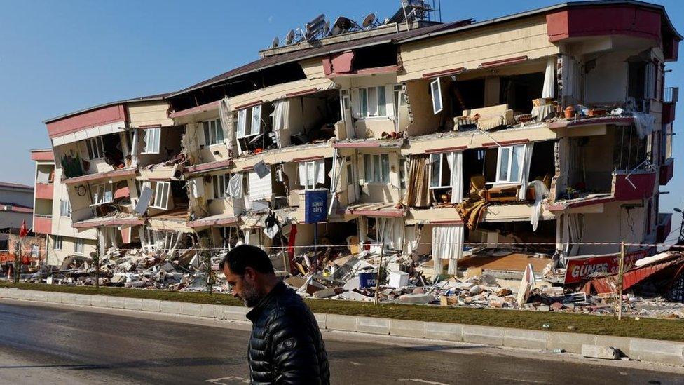 A man walks past a damaged building in the aftermath of a deadly earthquake in Kahramanmaras, Turkey, on 13 February 2023