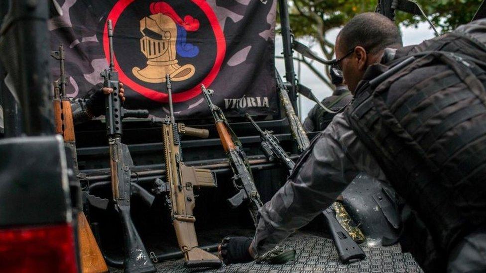 A member of the military police shows the weapons seized during a police operation in which they chased drug dealers escaping from Babilonia favela until catching them after a shootout in Vermelha beach at Urca neighbourhood, in Rio de Janeiro, Brazil, on June 8, 2018.