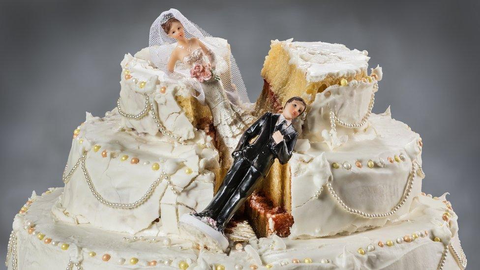 wedding cake with fallen figurines