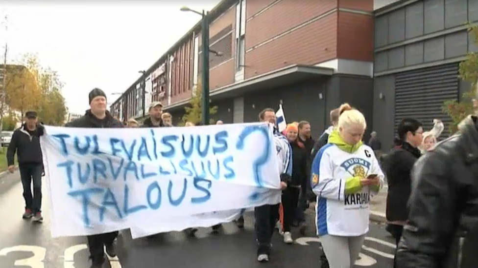 A woman in a Finland ice hockey shirt walking the protest march