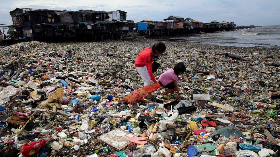 Children take advantage of stormy weather to collect rubbish brought onto the shore by high waves and winds, in metro Manila, Philippines, 20 October 2016.