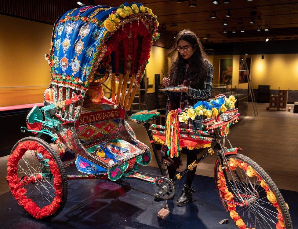 Artist Daya Bhatti puts the finishing touches to a decorated rickshaw artwork