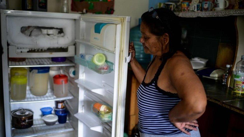 Luber Faneitte, a 56-year-old diagnosed with lung cancer, shows the inside of her fridge in her house in the San Agustin shanty town in Caracas on November 10, 2017.