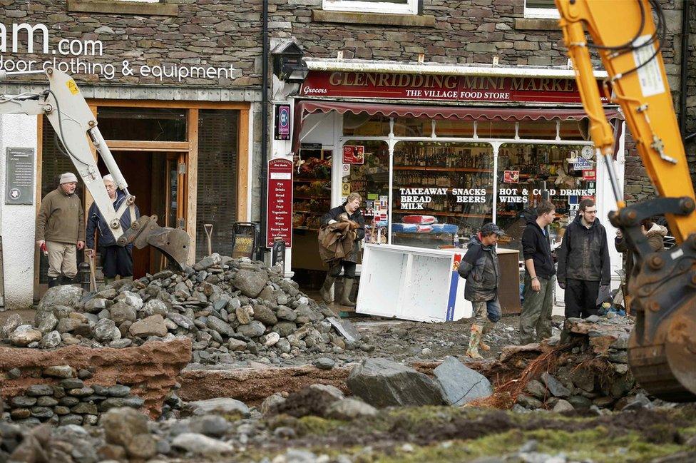 A digger clears rubble away outside the Glenridding Mini Market