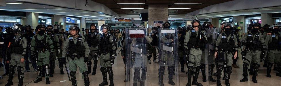 Hong Kong police line up at an MTR station on December 15