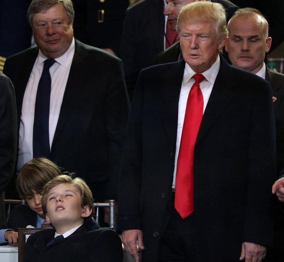 Barron Trump lying back with his eyes closed next to his father