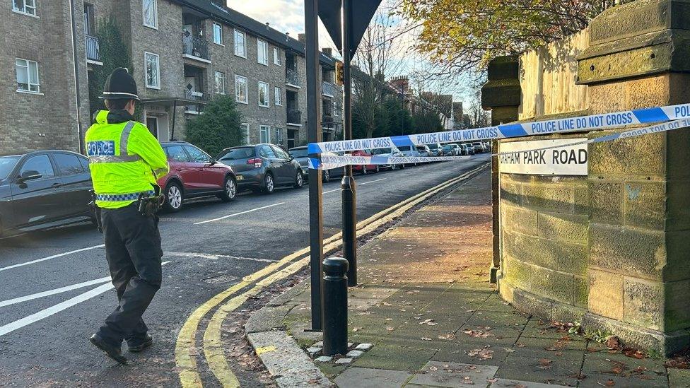 A police officer stands near a cordon on Graham Park Road