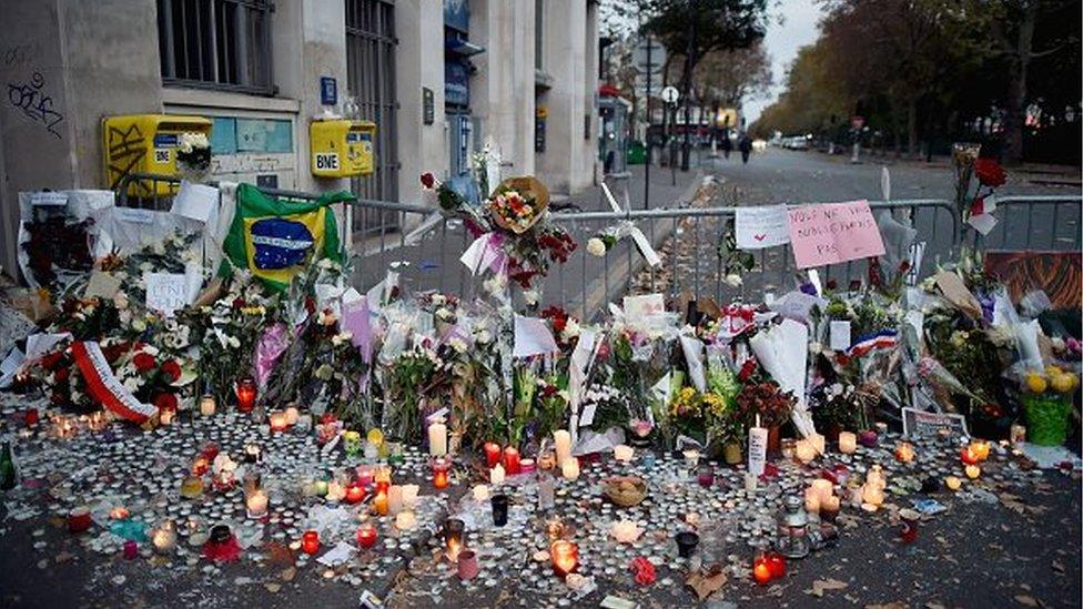 Flowers, candles and tributes cover the pavement near the scene of Friday's Bataclan theatre terrorist attack on November 15, 2015 in Paris, France.