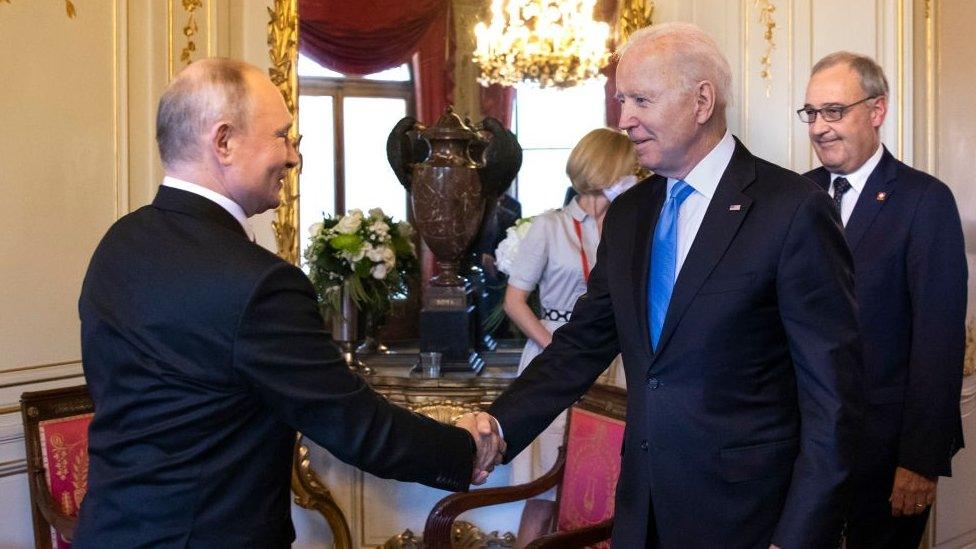 Vladimir Putin and Joe Biden shake hands