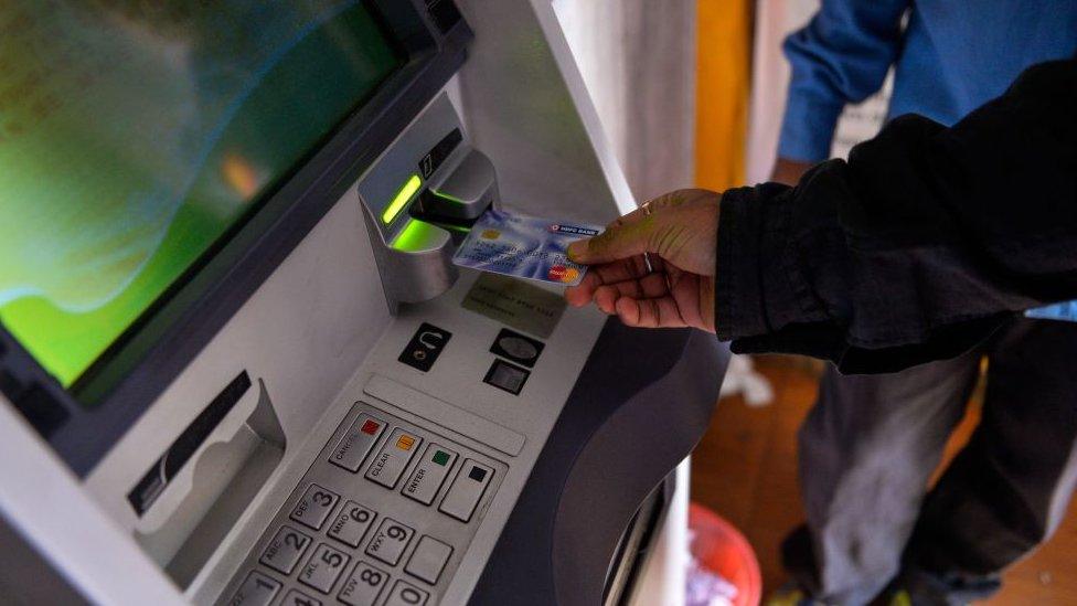 An Indian man inserts his card to withdraw money from a mobile bank ATM machine in New Delhi on November 15, 2016.