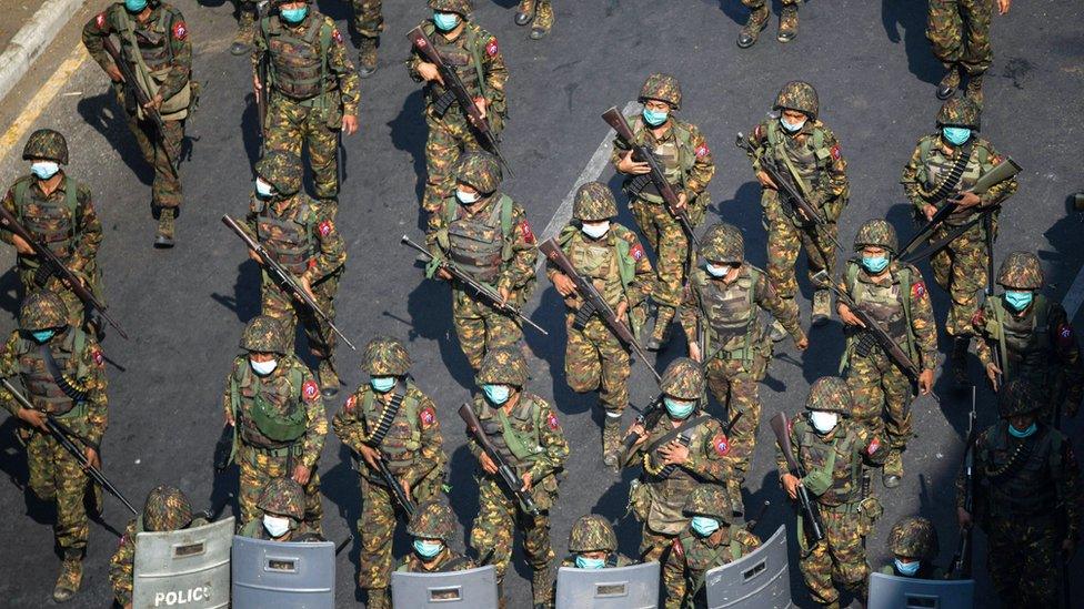 Myanmar soldiers walk along a street during a protest against the military coup in Yangon