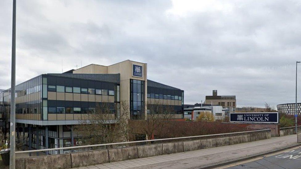 Concrete and glass campus building and University of Lincoln sign