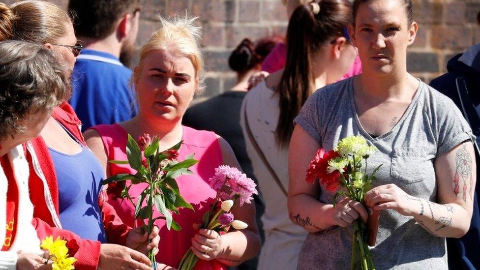 People carrying floral tributes