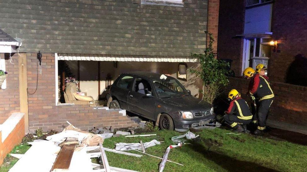 The car embedded in the wall of the house