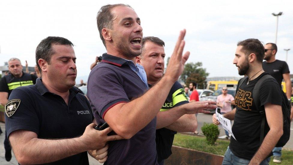 Police arrest a man at a protest in Tbilisi