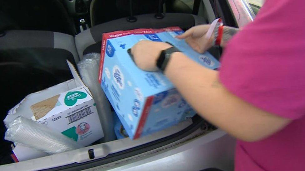 care worker carrying baby wipes from a car