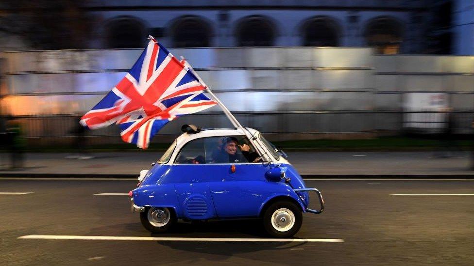 little-car-with-uk-flag-cheerful-man-driving