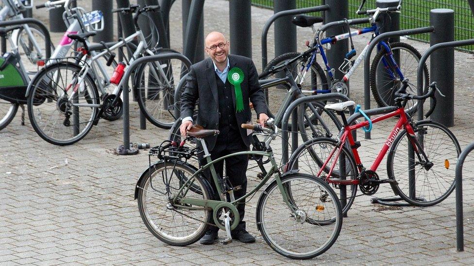 Scottish Green co-leader Patrick Harvie holds his bike, while surrounded by other bikes