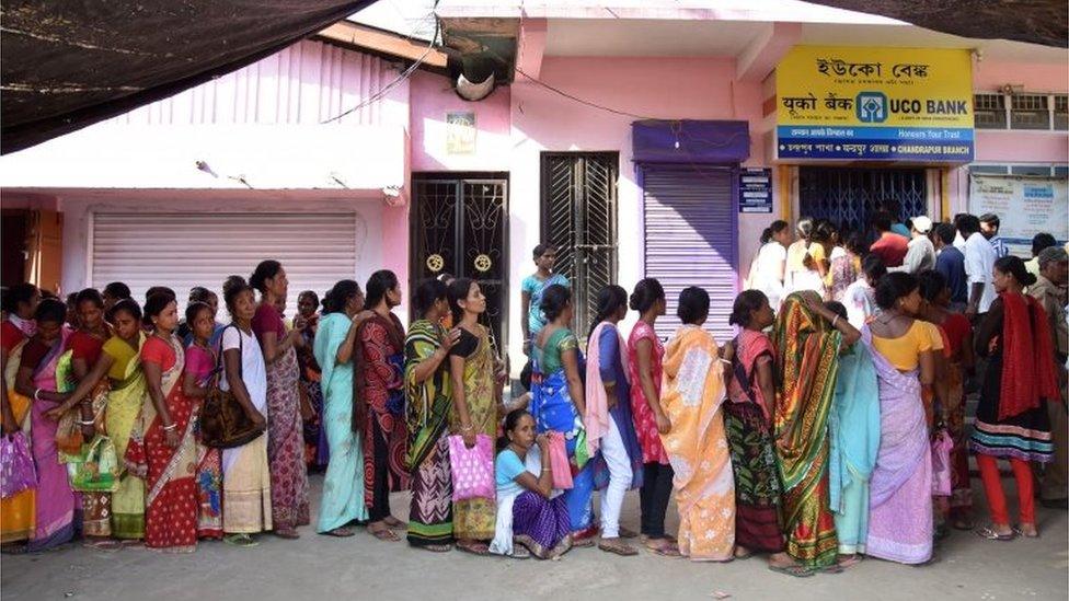 Indian villagers wait in a queue outside a bank to deposit and exchange 500 and 1000 rupee notes in Chandrapur Village, some 30 kms from Guwahati on November 15, 2016.